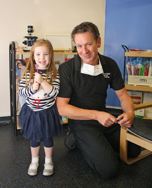 Davild Hilton, Principle smiling with a smiling child in Churchfield Dental Centre's waiting room